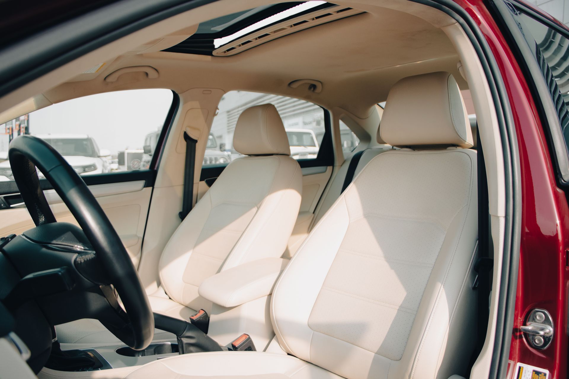Spacious car interior featuring elegant cream leather seats and modern design elements.